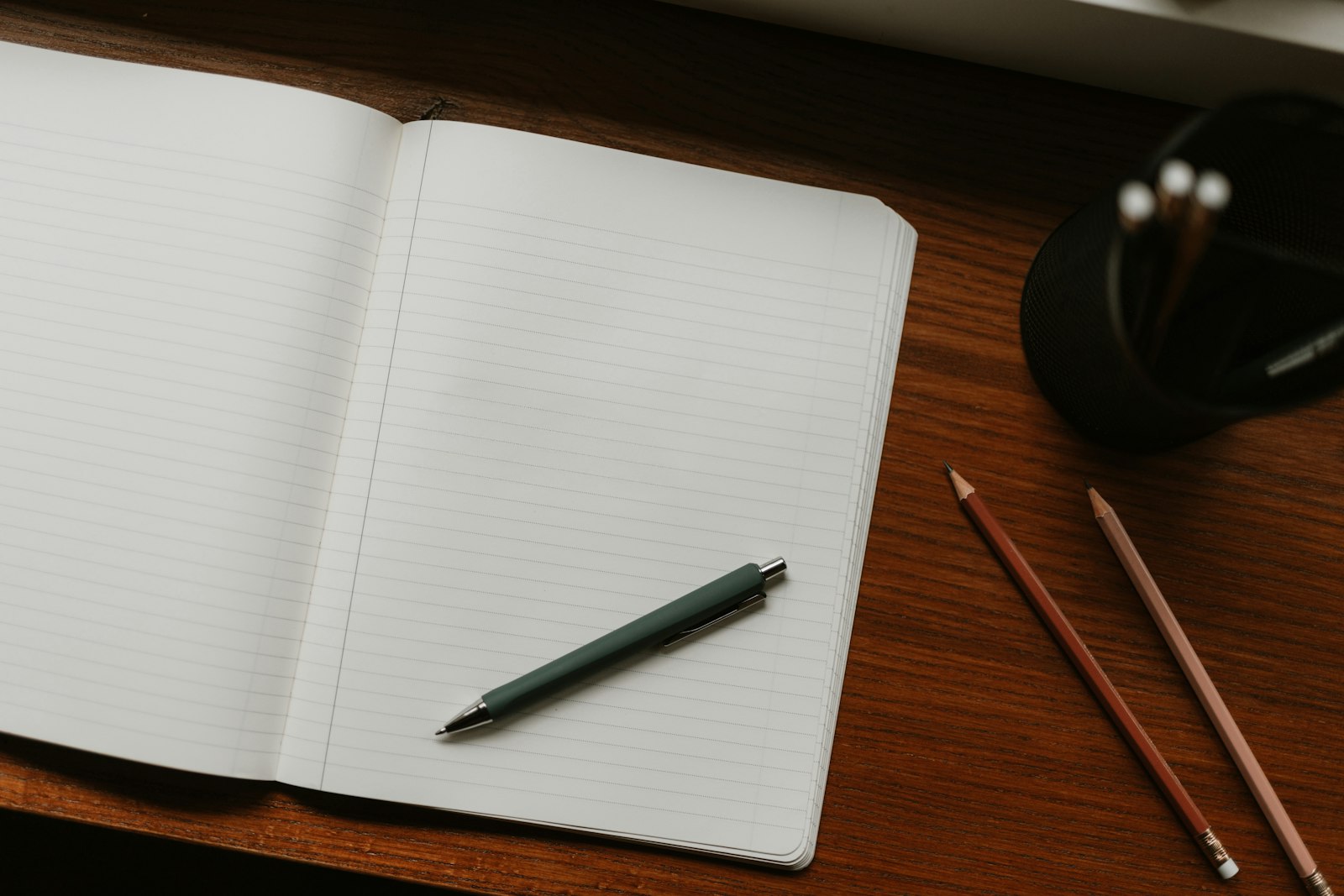 A notebook and pencils on a desk, mid-exploration during an early design session